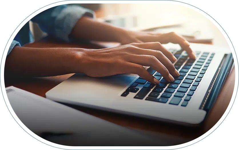 Hands typing on a computer researching top hand doctor in their area.